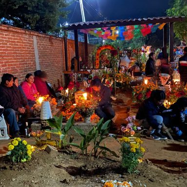Día de muertos, mexique Célébration nocturne avec des personnes autour d'autels décorés de fleurs et bougies.