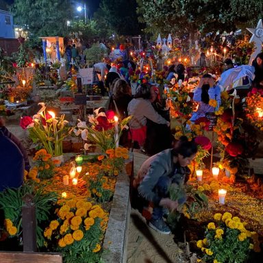 Díe de muertos, mexique Cimetière illuminé par des bougies et des fleurs, rassemblant des personnes en deuil.