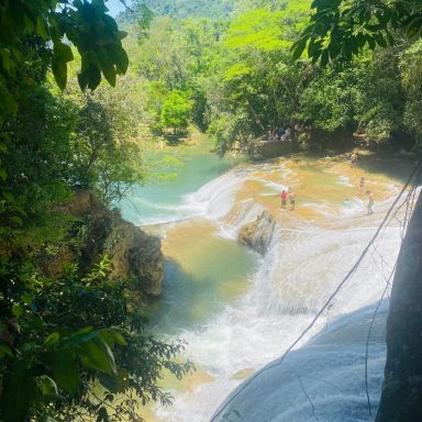 Cascades roberto barrios Chute d'eau entourée de verdure, avec des gens se baignant au bord.