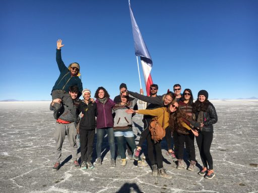 Salar d'uyuni, désert uyuni, Bolivie, Groupe de personnes souriantes posant sur une surface saline sous un ciel dégagé.