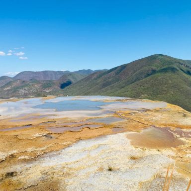 Hierve el agua, Chiapas Lac couleur terre entouré de montagnes sous un ciel bleu clair.